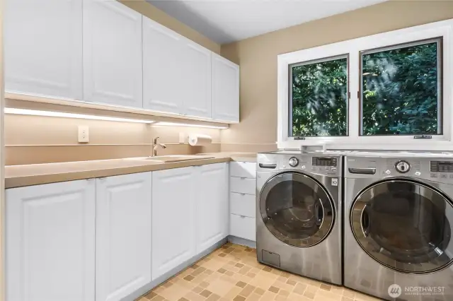 Featuring generous counter space and custom cabinets with drawers, this well-designed laundry room offers both functionality and convenience for all your storage needs.