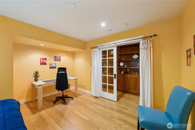 Multi-use office and/or bedroom. It has accommodated two desks on opposite walls and a guest bed between. French doors and a curtain offer layers of privacy.