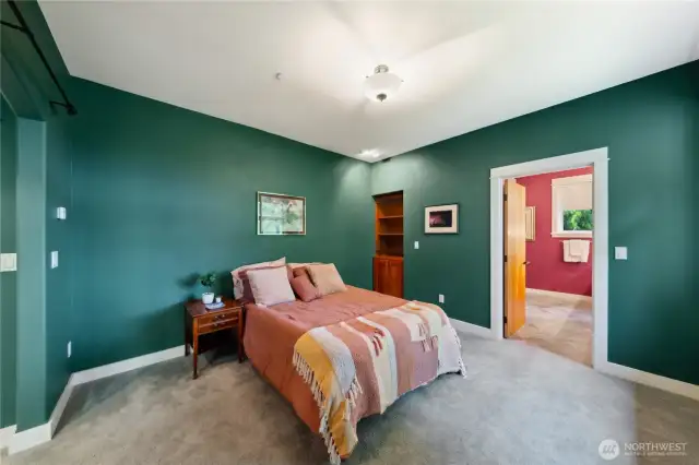 A cherry alcove is built into the far wall and there is the door leading to the primary bathroom.