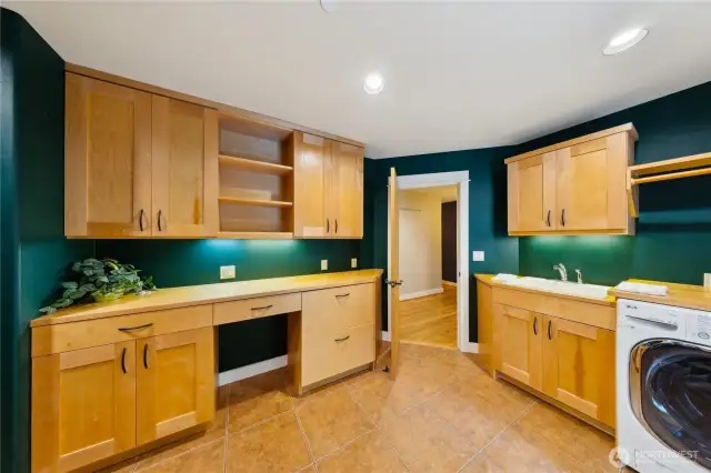 The laundry room/mud room, off the main hall has lots of storage, a hanging rod and utility sink.