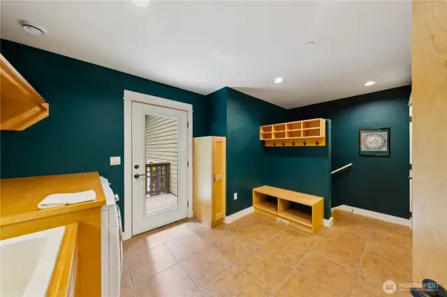 The laundry room/mud room has built-in bench, shelves, and coat hooks and exterior door to the yard. The stairs lead to the garage.