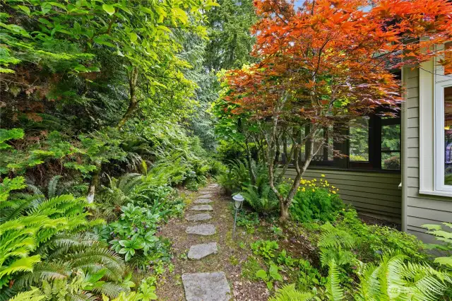 Stone pathways lead around the house through gorgeous landscaping to several decks and patios.