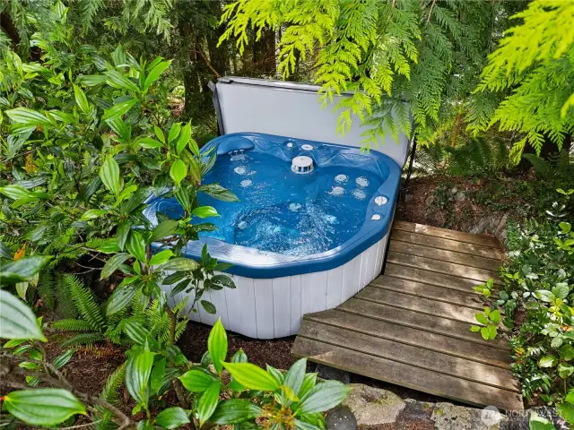 A private, bubbling jacuzzi is tucked away in the trees.