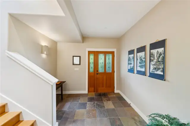 Slate tile entry hall features hand made botanical lighting sconces. The stairs lead to the 2nd bedroom suite loft.