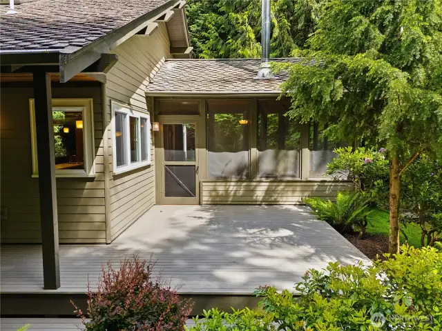 The screened porch from the outside, opens out onto a large deck area.