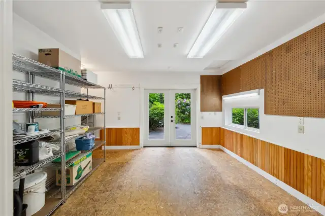 Large workshop, also with heated floors, 220 outlets, overhead and task lighting, fully finished, with wainscoting. The door to the garage is on one end, and the back patio is through the double doors.
