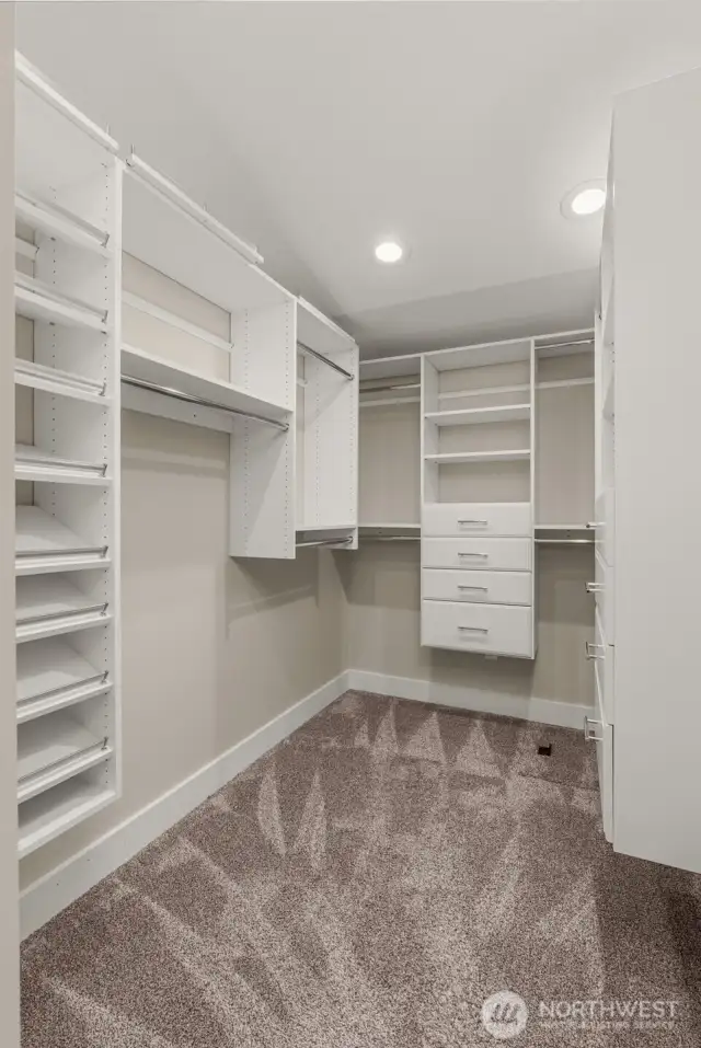 Walk-in primary closet with custom built-ins.