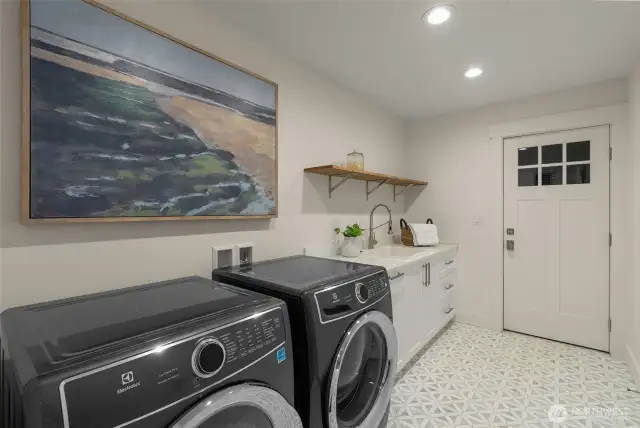Laundry / mud room features a door that leads to a side deck that connects to the garage.
