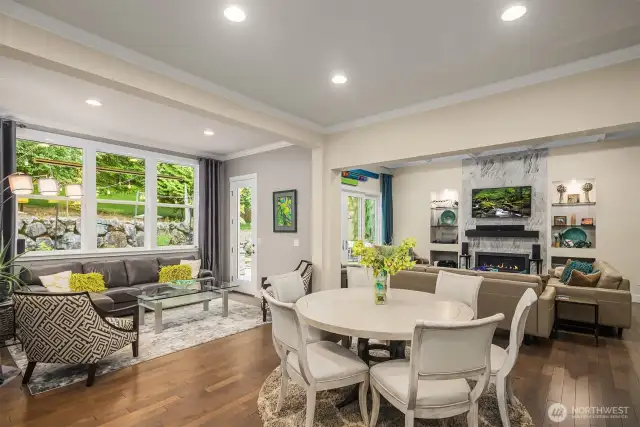 The great room has so many different spaces and walls of glass taking in the natural light and greenscape.