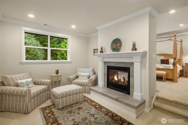 Upstairs, the luxurious primary suite has a two-sided gas fireplace that serves both the private sitting room and the bedroom area.