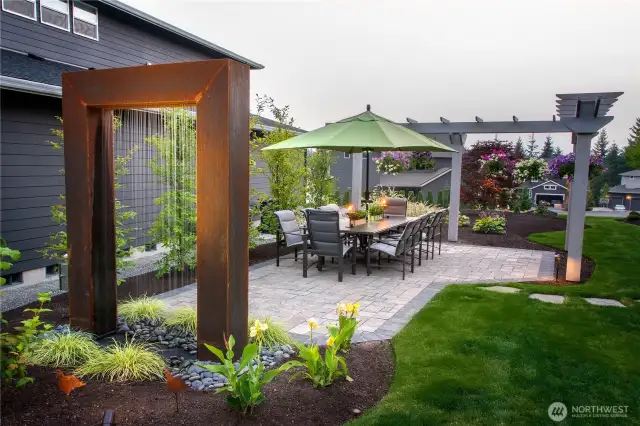 The separate dining area is graced by the sights and sounds of this gorgeous sculptural water curtain.