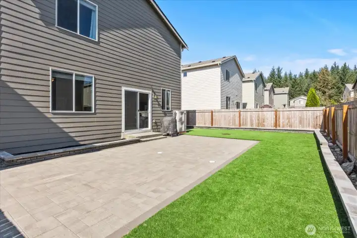 $17,000 in upgrades! Low-maintenance backyard with large stone patio and premium artificial turf.