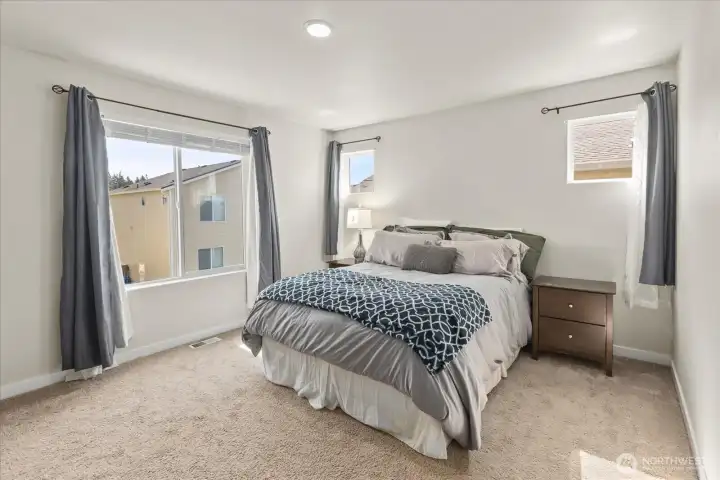 Primary suite featuring a walk-in closet and an ensuite bath.