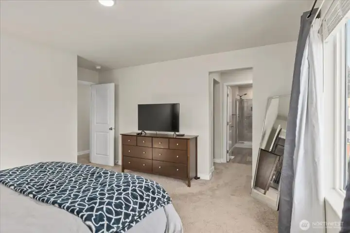 Primary suite featuring a walk-in closet and an ensuite bath.