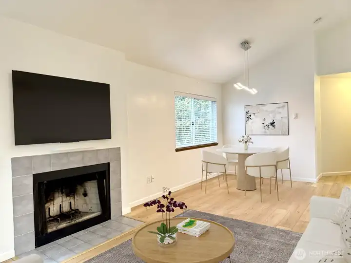 Wood-burning fireplace in virtually staged living and dining area