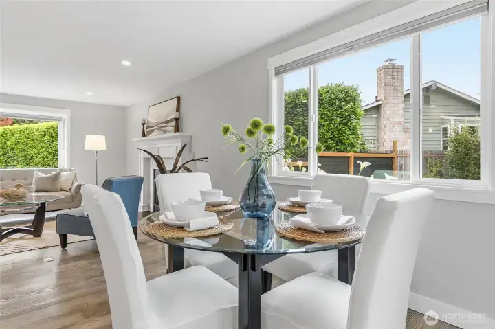 Bright Dining Area with Rich Hardwood Flooring, Expansive Windows, and Glass Door access to Big Private Deck and Fenced Backyard features Abundant Natural Light, Contemporary Finishes, and Seamless Indoor-Outdoor Flow Ideal for Everyday Dining, Backyard Barbeques, and Entertaining