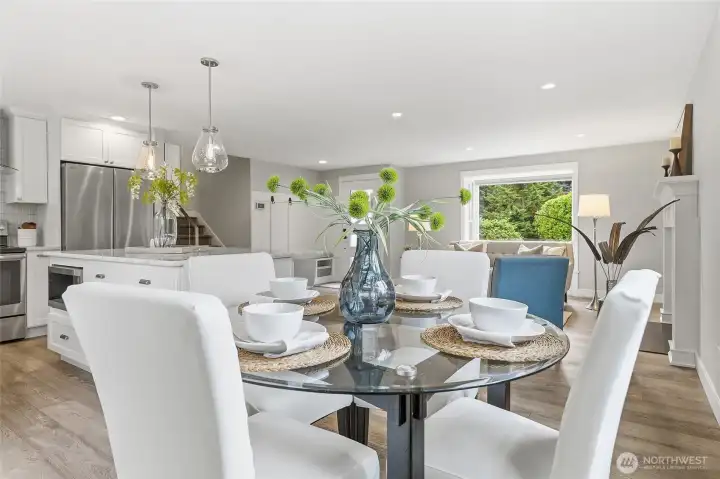 Bright Dining Area with Rich Hardwood Flooring, Expansive Windows, and Glass Door access to Big Private Deck and Fenced Backyard features Abundant Natural Light, Contemporary Finishes, and Seamless Indoor-Outdoor Flow Ideal for Everyday Dining, Backyard Barbeques, and Entertaining