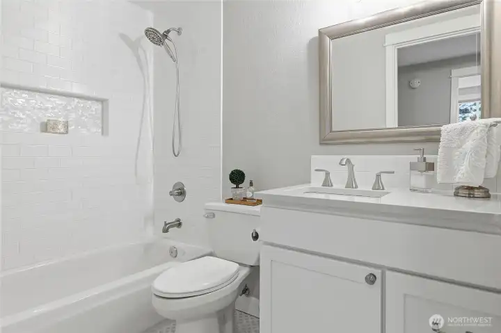 Remodeled Main Bath featuring Raised Mirrored Vanity with Quartz Counter and Designer Lighting.