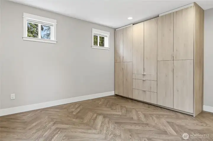 Family Room with Access to Backyard and Built-in Storage Closet can be used as a 2nd Primary Bedroom with New En-suite Bath featuring a Raised Mirrored Vanity with Quartz Counters, Double Sinks, Designer Lighting, Heated Tile Floors, and Stacked Washer and Dryer.
