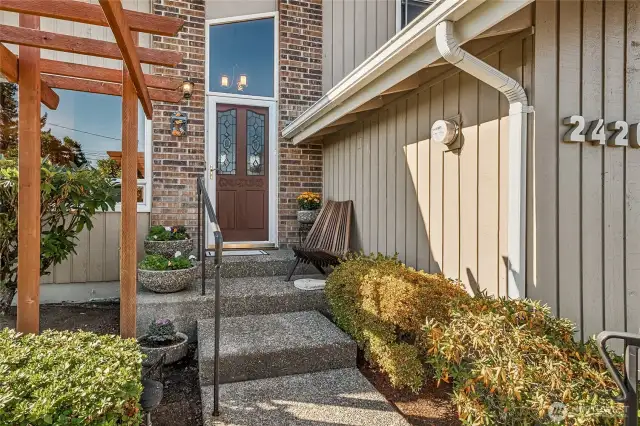 An inviting entry walkway with modern concrete and handrails, guides you or your guests to the front door