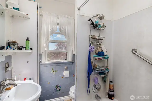 Upstairs full bathroom with pedestal sink and extra storage.