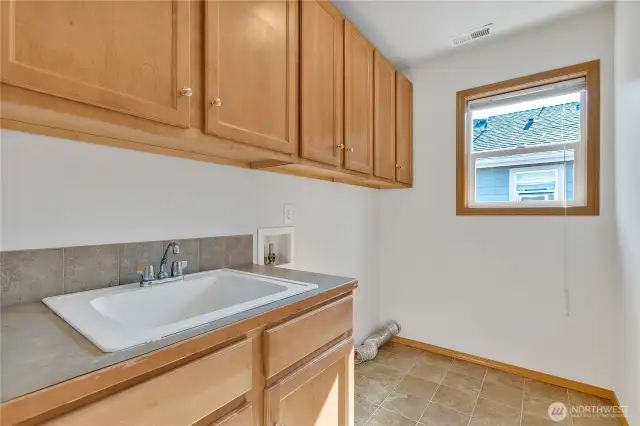 Upstaris Laundry with abundant storage cabinets and utility sink!