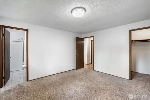 Primary bedroom with walk in closet and private bathroom