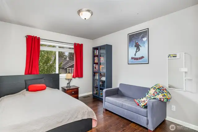 Bedroom adjacent to main bath, with ample closet space and a large window facing the backyard.