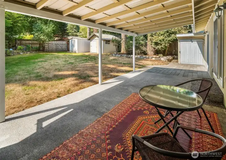 The covered back patio is the ideal space to host gatherings through all of the seasons. Check out all of those awesome outbuildings waiting on your gardening tools and yard games!