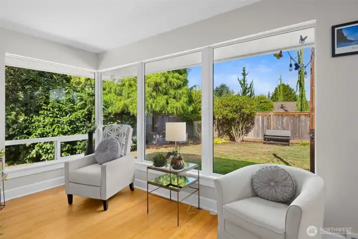 Peaceful corner framed by large windows overlooking the backyard