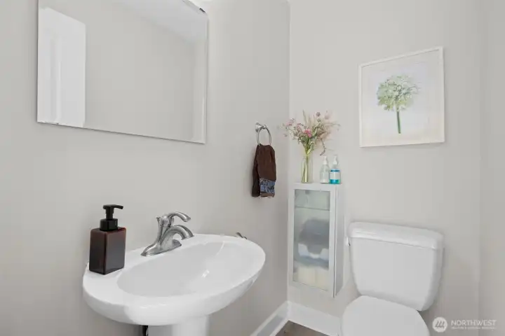 Crisp half bath with pedestal sink and modern finishes