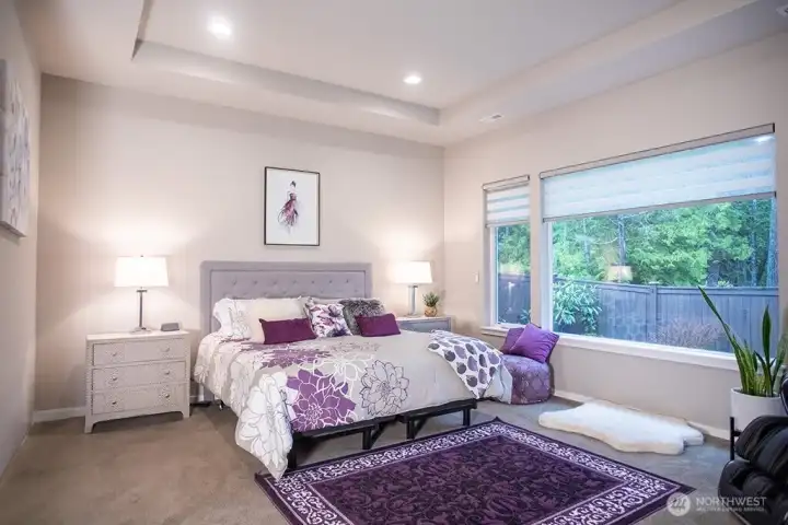 primary bedroom with large windows and high end remote control blinds.