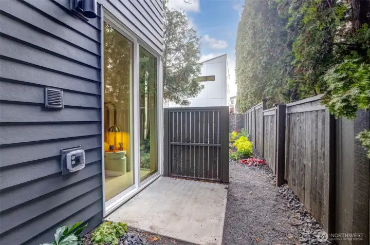 Entry-level guest suite features a large glass slider to a private patio, offering flexible work-from-home potential.