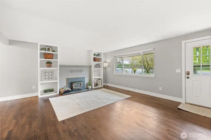 Wall to ceiling built-ins, wood-burning fireplace, and a large entry window for tons of natural light.