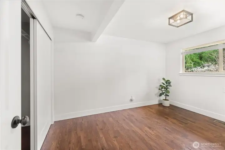 Primary Bedroom: Window, wood blinds, large closet.