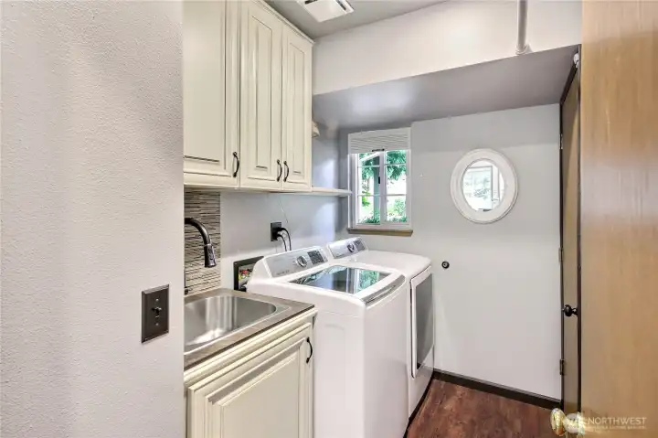 Utility room with sink and storage cabinets