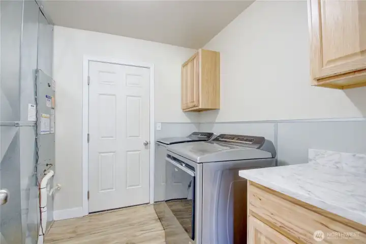 Laundry with storage and access to garage.