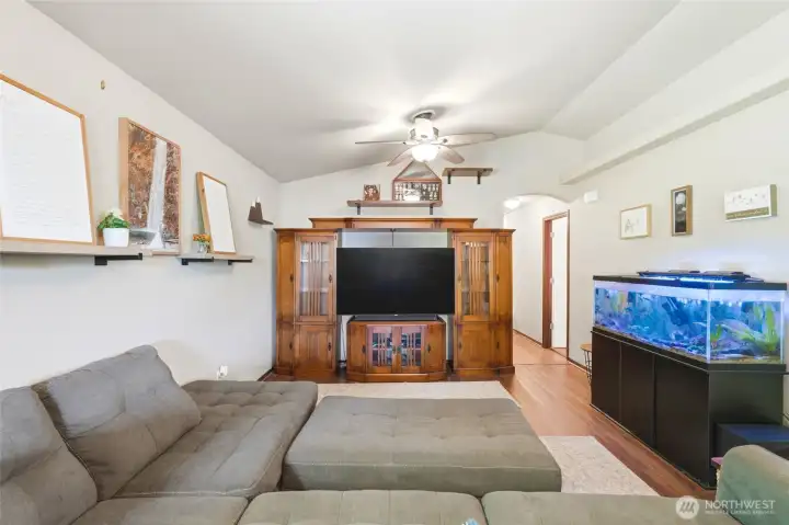 An open floor plan, the vaulted ceiling continues through the living room, dining, and kitchen.