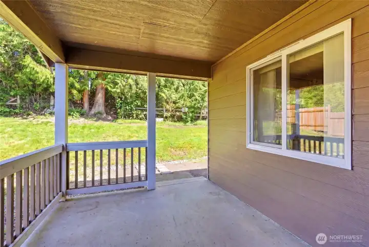 Covered rear patio accessed from sliding door in kitchen.