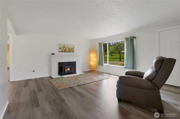 Living room with wood burning insert in fireplace. 2019 new flooring installed, LVP by Shaw, waterproof