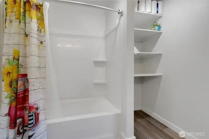 Full bath with storage shelves