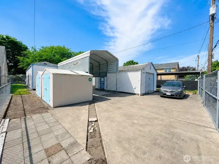 Large secure fenced backyard with so many possibilities, 2 sheds with skylights, RV covered parking, workshop with two heaters and loads of storage