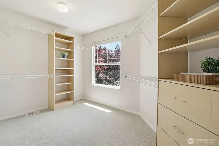 Primary walk-in closet with window for extra lighting