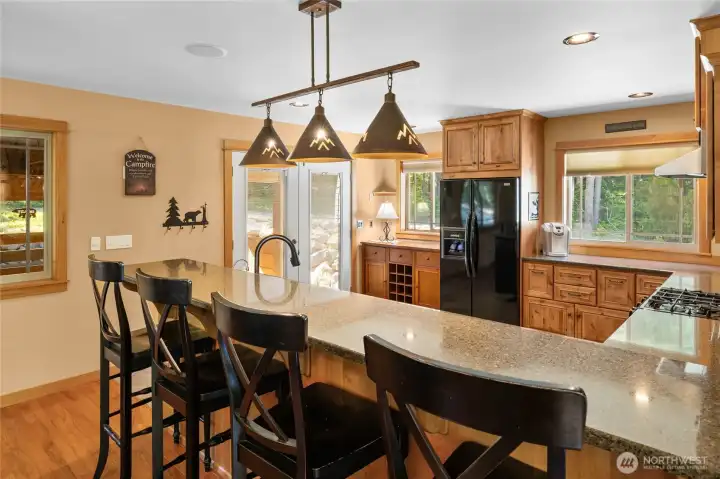 Looking into the kitchen space from the raised eating bar with granite counters!