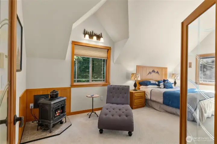 Upper Level 2- French doors lead to the large Primary Suite! Cozy corner propane stove for a quiet reading spot.