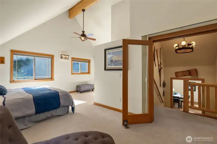 Primary Suite- vaulted ceilings & exposed beams show off in this space. The french doors have privacy panels too!