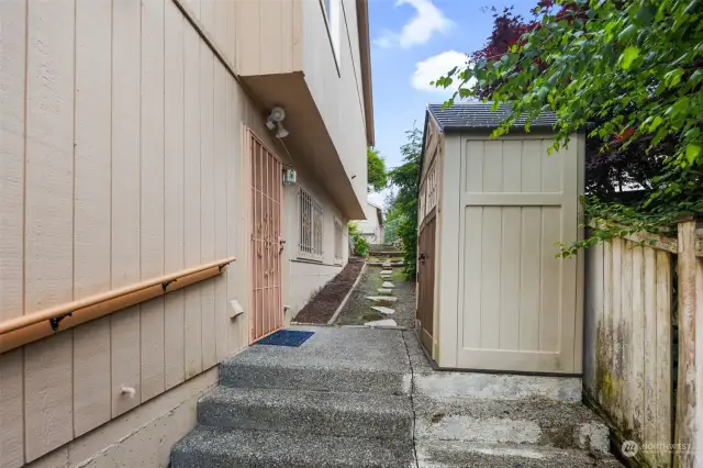 Side of home with access to lower level along with a shed