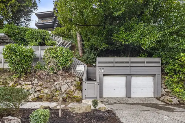 Walk down the stairs to the lower level amenities including: large partially covered deck + two separate garages for extra storage.