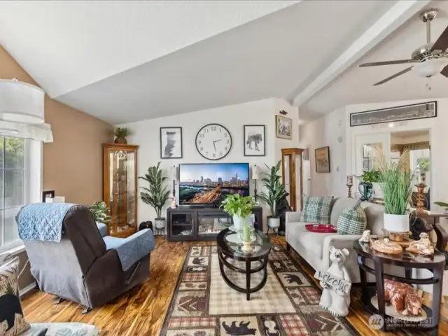 Large family room with vaulted ceilings and engineered hardwood flooring.