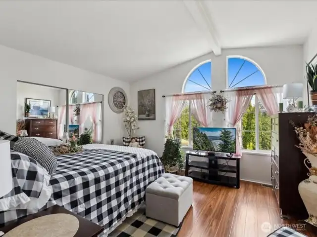 Primary bedroom is large with big windows allowing a lot of natural light.  Nice flooring and vaulted ceilings.